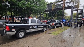 Puente peatonal acordonado con una cinta policiaca con patrullas y policías de Guadalajara resguardando debajo
