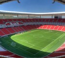 Vista panorámica y aérea del Estadio Akron (de Chivas) en Guadalajara. El campo de fútbol verde brillante está rodeado por miles de asientos de color rojo inten