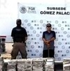 Hombre esposado y con los ojos censurados por un recuadro negro en medio de dos agentes de la FGR delante de varios paquetes de metanfetamina