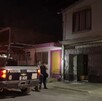 Se observa una patrulla, una mujer policía y otras personas de pie; es de noche.