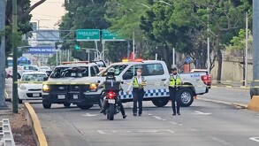 Oficiales y patrulla de la Policía Vial resguardando un área acordonada sobre Avenida Vallarta donde un motociclista murió