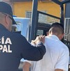 Se observa a un policía sometiendo a un hombre que está de espaldas.