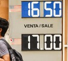 Gente caminando frente a un banco de cambio.