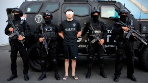 Joven Cristian ‘N’ originario de Estados Unidos con los ojos censurados por un recuadro blanco mientras es detenido por policías de Jalisco con armas largas