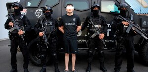 Joven Cristian ‘N’ originario de Estados Unidos con los ojos censurados por un recuadro blanco mientras es detenido por policías de Jalisco con armas largas