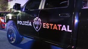 Vista lateral de una patrulla de la Policía del Estado de Jalisco durante la noche con el logotipo de la dependencia grabado en la puerta del conductor
