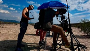 Se observan  hombres sentados y están filmando con cámaras de video.