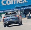 Se observa un carro sobre la calle y al fondo un letrero.