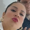 Mujer maquillada sonriendo para una fotografía.