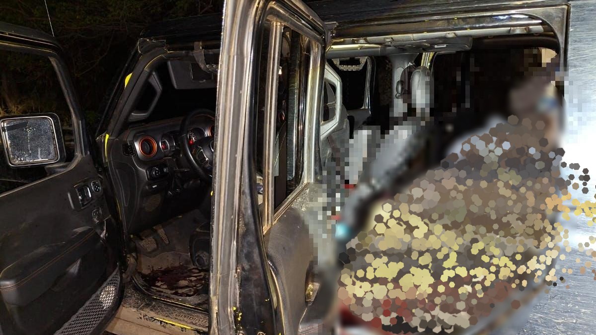Cuerpo de un hombre censurado y blureado dentro de una camioneta Jeep negra con las puertas abiertas