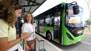 Mujer en parada de camión, y una unidad d etransporte público