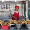 Hombre prepara comida en un puesto callejero en CdMx