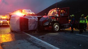 Se observa un tractocamión siniestrado y una camioneta destrozada tras un choque; es de noche.