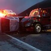 Se observa un tractocamión siniestrado y una camioneta destrozada tras un choque; es de noche.