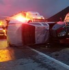 Se observa un tractocamión siniestrado y una camioneta destrozada tras un choque; es de noche.
