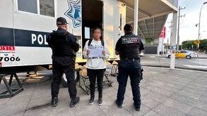 Joven con la cara censurada con blur sosteniendo una hoja en medio de dos oficiales de la Policía de Tlaquepaque