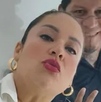 Mujer maquillada sonriendo para una fotografía.