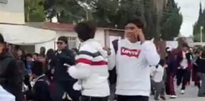 Estudiantes corriendo por una explosión cerca de su escuela.