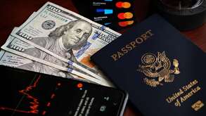 Pasaporte estadounidense con dólares y un teléfono celular