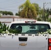 Camioneta en color blanco junto a ramo de flores