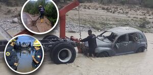 Carro hundido en el agua, autoridades de seguridad con el agua a mitad del cuerpo y árbol caído