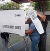 Se observa a un hombre dentro de una casilla electoral.
