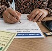 Manos de mujer con celular y pluma de escribir en la mano