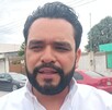 Se observa a un hombre con camisa blanca y tiene barba.