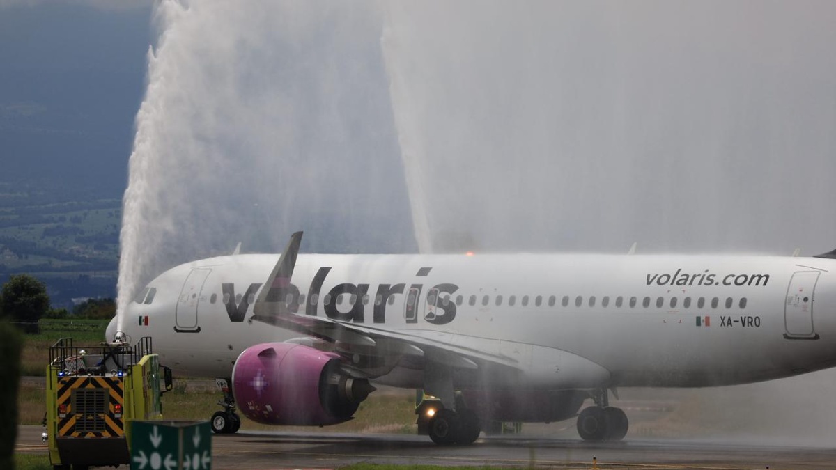 Avión en medio de chorro de agua por la celebración de la inauguración con la marca de la línea Volaris