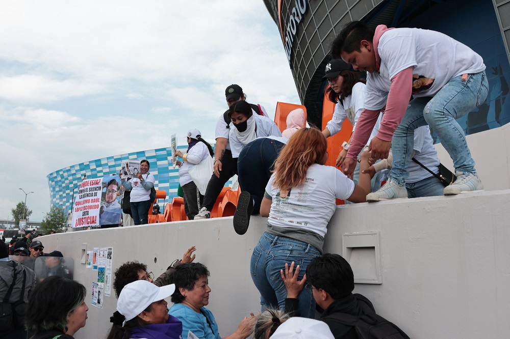 Manifestantes suben a una tarima improvisada para protestar.