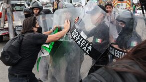 Manifestante peleando con un policía en Puebla.