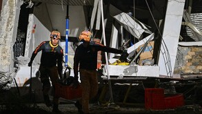 Los equipos de rescate transportan material fuera de un edificio derrumbado tras un terremoto de magnitud 7,8