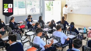 alumnos de Jalisco y un maestro reunidos dentro de un salón durante una clase en una escuela