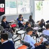 alumnos de Jalisco y un maestro reunidos dentro de un salón durante una clase en una escuela