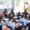 alumnos de Jalisco y un maestro reunidos dentro de un salón durante una clase en una escuela