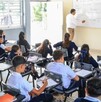 alumnos de Jalisco y un maestro reunidos dentro de un salón durante una clase en una escuela