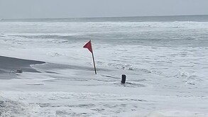 Bandera roja clavada en medio de la costa de playa Pascuales en Tecomán, Colima alertando del alto oleaje y la peligrosidad del mar