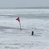 Bandera roja clavada en medio de la costa de playa Pascuales en Tecomán, Colima alertando del alto oleaje y la peligrosidad del mar