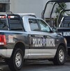 Patrullas de la Policía Municipal de Guadalajara estacionadas al exterior de una casa blanca con rejas negras