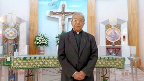 Se observa a un sacerdote adulto mayor que está dentro de una iglesia.