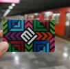 Mano sujetando una tarjeta de movilidad frente al metro