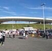 Vista del exterior del Estadio Akron o Estadio Guadalajara en el área del estacionamiento con aficionados y automóviles alrededor