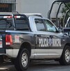 Patrullas de la Policía Municipal de Guadalajara estacionadas al exterior de una casa blanca con rejas negras