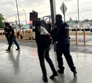 Se observa  un hombre que lo llevan esposado de las manos.
