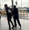 Se observa  un hombre que lo llevan esposado de las manos.