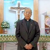 Se observa a un sacerdote adulto mayor que está dentro de una iglesia.