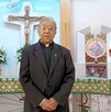 Se observa a un sacerdote adulto mayor que está dentro de una iglesia.