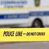 Área acordonada por una cinta policiaca amarilla en Estados Unidos con un camión de peritos de la policía desenfocado en el fondo