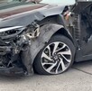 Vista de la fascia y parte de la puerta de un automóvil Honda Civic color negro destruidas tras ser impactadas por una patrulla de Zapopan