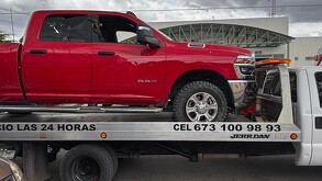 Camioneta roja arriba de un tráiler